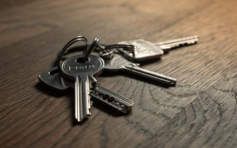 A set of metal keys on a wooden surface.